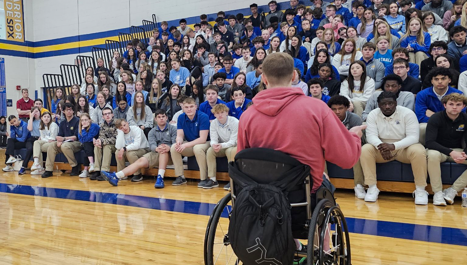 man in wheel chair talking to students